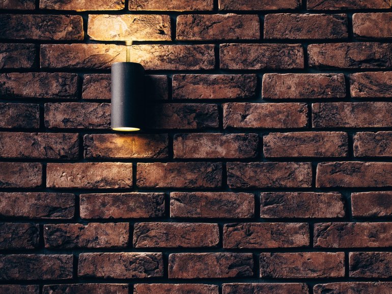 A natural stone wall with a hung lamp.